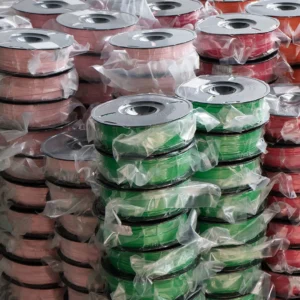 stacked 3D printing filament spools vacuum sealed in plastic bags green pink red bulk filament storage