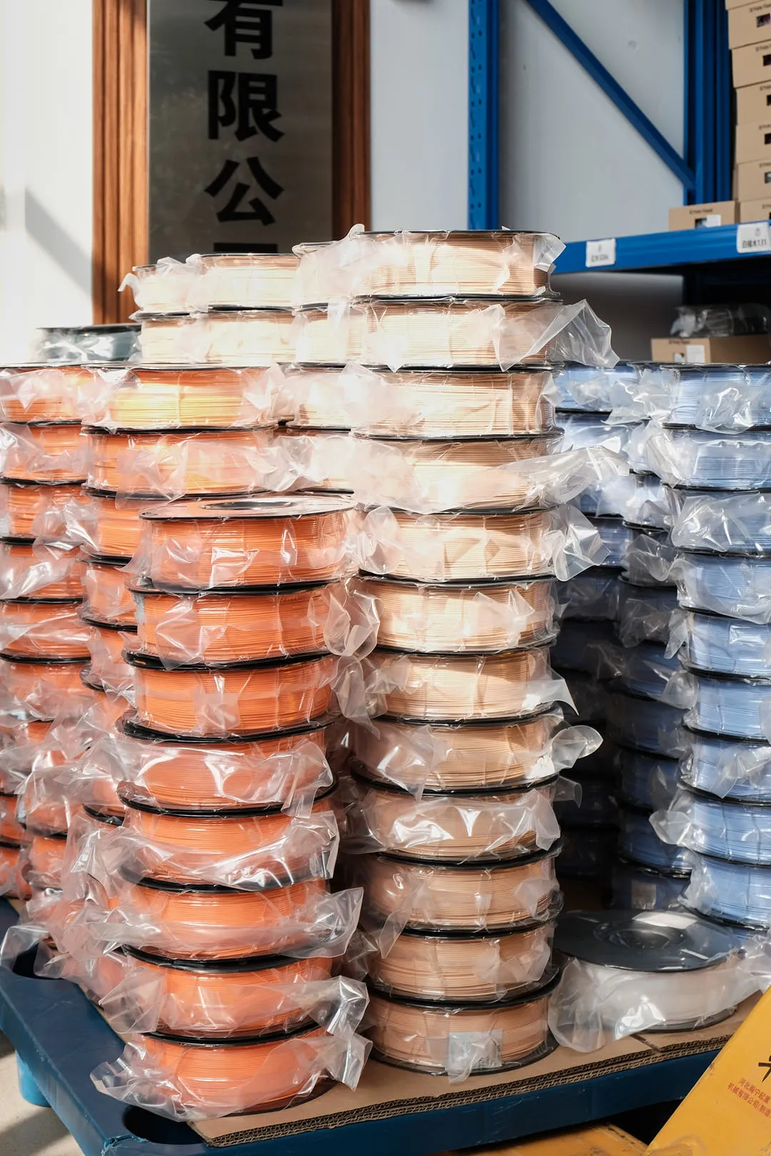 stacked 3D printing filament spools vacuum sealed in plastic bags bulk supply multi color warehouse storage