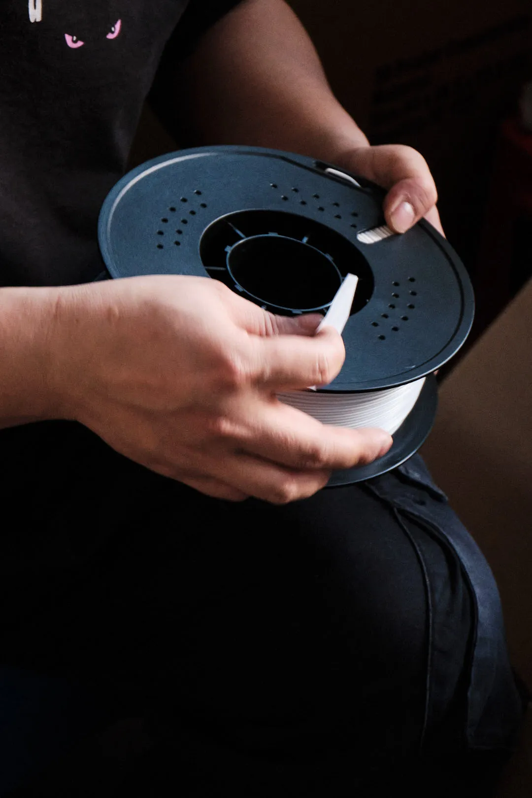 Worker assembling and labeling 3D printing filament spool for OEM packaging