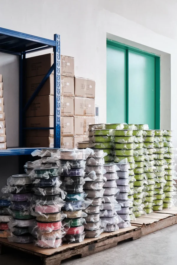 asa bulk filament spools stacked on pallets wrapped in plastic in warehouse storage area