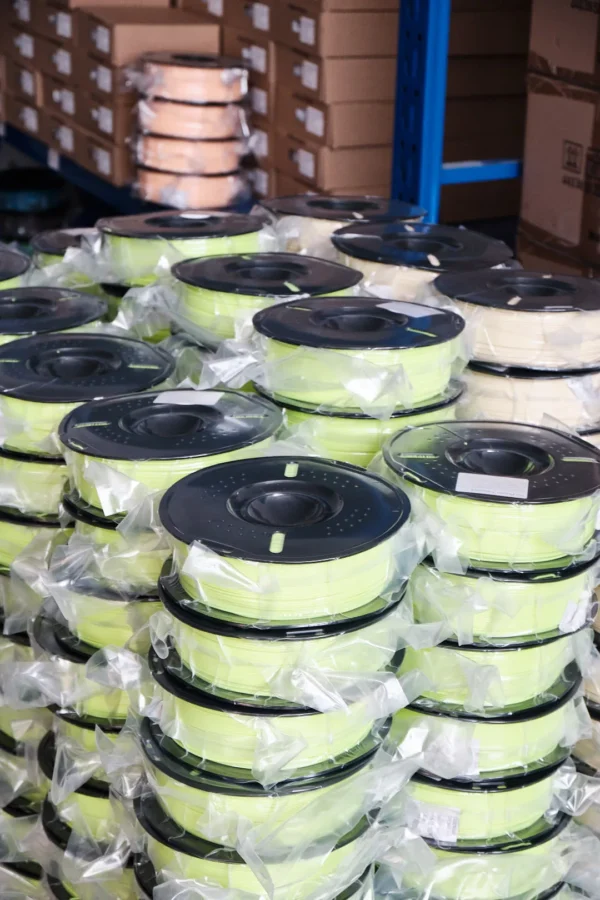 bulk abs filament spools stacked and wrapped in plastic for warehouse storage and wholesale supply