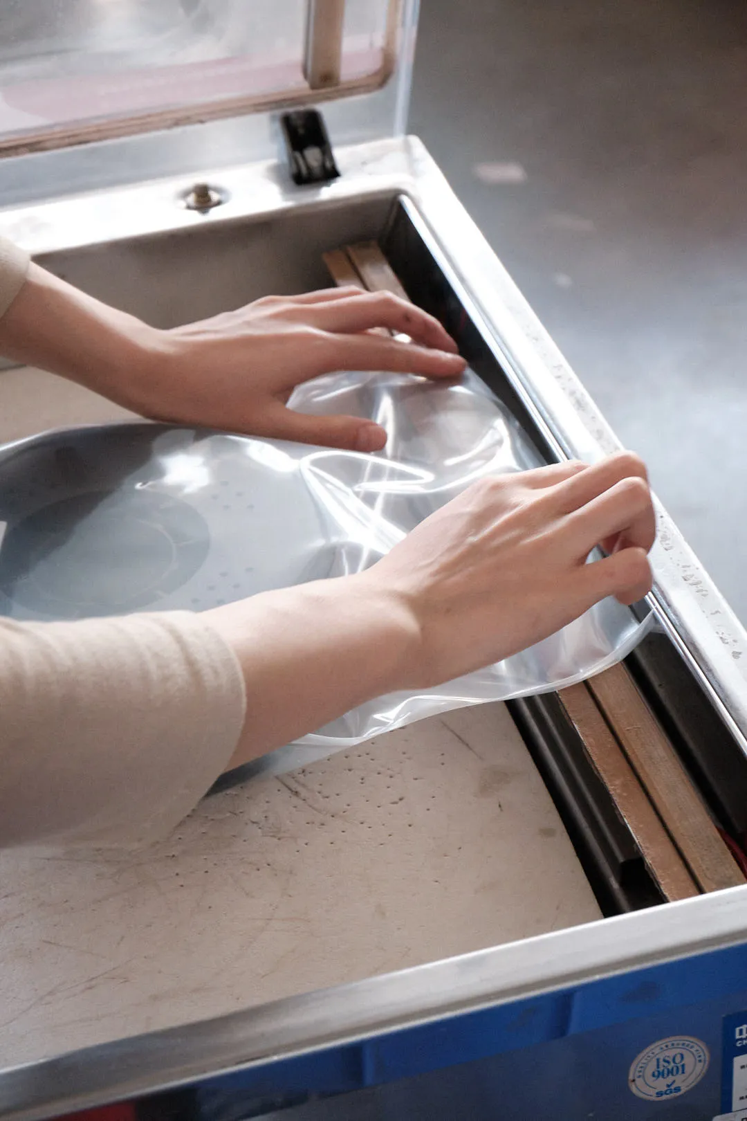 PLA filament spool being placed into a vacuum storage bag to protect from moisture
