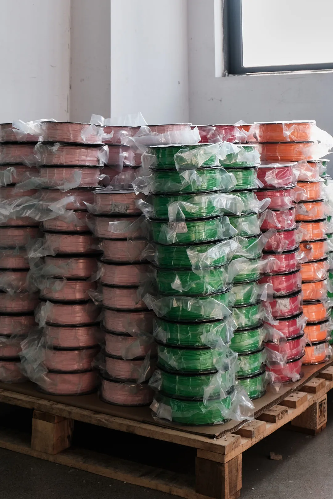 bulk petg filament spools stacked on pallets wrapped in plastic for wholesale shipping