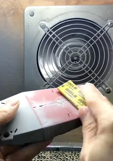 hand sanding PLA 3D printed part with sandpaper to smooth surface